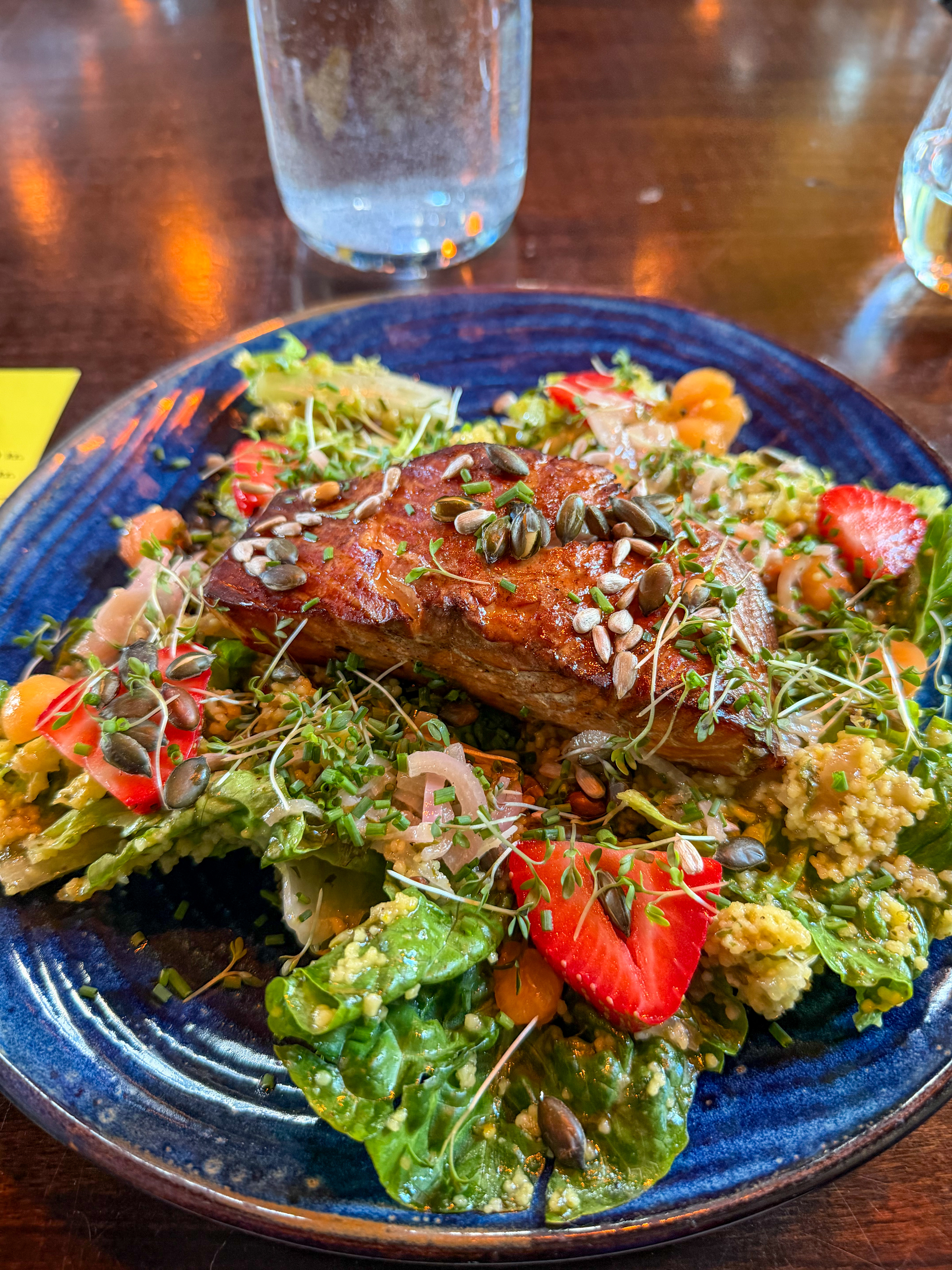 Seared fish with strawberries, toasted seeds and garden greens